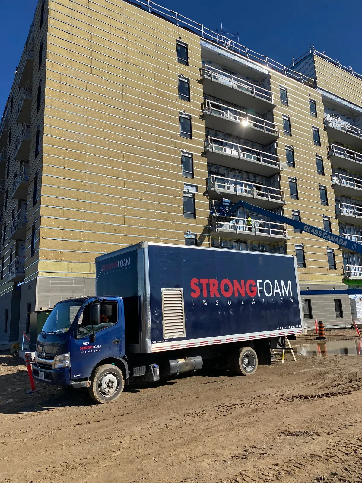 Strong Foam truck in front of a residential tower under construction