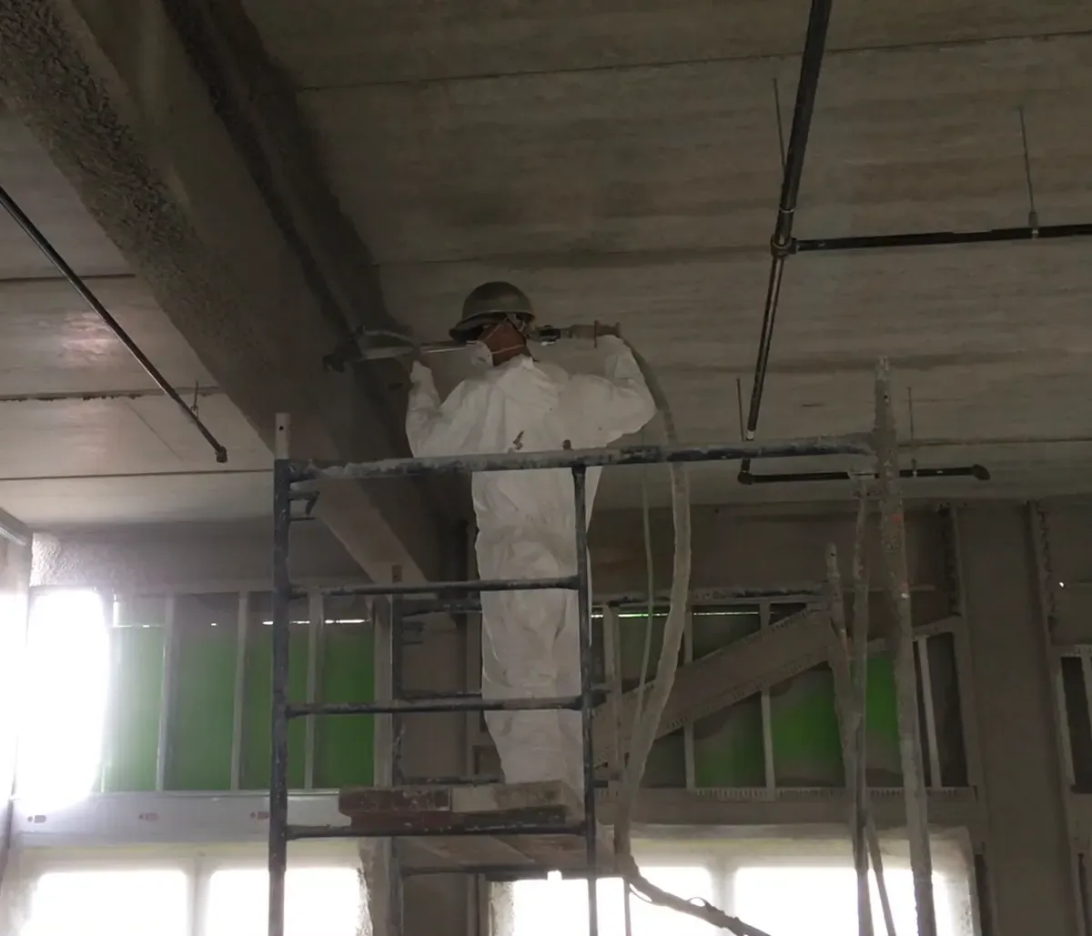 Fireproofing being spray-applied to a structural ceiling