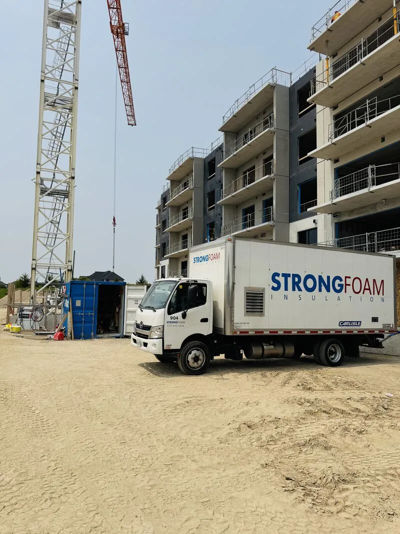 Strong Foam truck on a residential construction site beside a tower crane